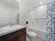 Bright bathroom features a shower-tub combo with decorative blue floral shower curtain and a white vanity sink at 22010 Seyburn Ter, Port Charlotte, FL 33954