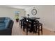 Stylish dining area with a wooden table, seating for eight, a modern clock, and natural light at 22010 Seyburn Ter, Port Charlotte, FL 33954