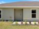 Close-up view of the front door, complemented by decorative plants and a security system sign at 22010 Seyburn Ter, Port Charlotte, FL 33954