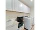 Bright laundry room features a white sink, with white cabinets and white washer and dryer at 22010 Seyburn Ter, Port Charlotte, FL 33954