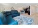 Open-concept living area flowing into the kitchen, complete with bar seating and a comfortable blue sofa at 22010 Seyburn Ter, Port Charlotte, FL 33954