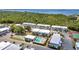 Aerial view showcasing a pool, tennis court, bocce ball, landscaping, parking, and nearby waterway for the community at 22375 Edgewater Dr # 255, Punta Gorda, FL 33980