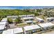 An aerial view shows the property with a pool, tennis court, bocce ball, landscaping, parking, and nearby waterway at 22375 Edgewater Dr # 255, Punta Gorda, FL 33980
