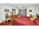 Bright bedroom features hardwood floors, ceiling fan, a mounted TV, a dresser, and a door to the sunroom at 22375 Edgewater Dr # 255, Punta Gorda, FL 33980