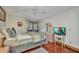 Bright bedroom features a ceiling fan, wood floors, a dresser, and a mounted TV on a small white table at 22375 Edgewater Dr # 255, Punta Gorda, FL 33980