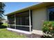 Home exterior view featuring an enclosed porch and vibrant hibiscus bush at 24141 Green Heron Dr # 23, Punta Gorda, FL 33980