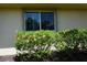 Exterior shot of house with flowering hibiscus bush in front of a window at 24141 Green Heron Dr # 23, Punta Gorda, FL 33980