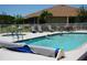 Community swimming pool with clear blue water, featuring people swimming, patio furniture, and a well-maintained deck at 24141 Green Heron Dr # 23, Punta Gorda, FL 33980