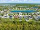 An aerial view shows the home is in a residential neighborhood with access to lakes and a forested area at 2427 Carnation Ct, North Port, FL 34289