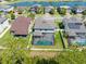 Aerial view of a home with a screened pool, fenced yard, and lake in a deed restricted community at 2427 Carnation Ct, North Port, FL 34289