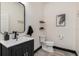 Modern half bathroom with a sleek black vanity, stylish mirror, and contemporary fixtures at 2427 Carnation Ct, North Port, FL 34289