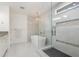Bright bathroom features a soaking tub, a chandelier, and a glass enclosed shower at 2427 Carnation Ct, North Port, FL 34289