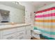 A cheery bathroom with dual sinks and colorful shower curtain at 2427 Carnation Ct, North Port, FL 34289