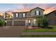 Two-story home with a three-car garage and a colorful sunset background at 2427 Carnation Ct, North Port, FL 34289