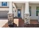 Inviting front entrance with stone accents on columns, a brick path, and a stylish blue front door at 2427 Carnation Ct, North Port, FL 34289