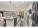 Open concept kitchen boasts a center island, stainless appliances, and seamless flow to dining and living areas at 2427 Carnation Ct, North Port, FL 34289