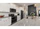 Modern kitchen features stainless steel appliances, granite countertops, white cabinetry, and ample counter space at 2427 Carnation Ct, North Port, FL 34289