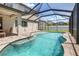 Screened-in pool with tanning ledge, surrounding greenery, and adjacent outdoor dining area at 2427 Carnation Ct, North Port, FL 34289
