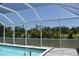 Screened in pool with partial privacy screen and view of lush landscaping at 2538 Dongola St, North Port, FL 34291