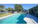 View of the in-ground swimming pool, backyard storage shed, surrounding trees, and partially fenced yard at 2621 Larkspur Dr, Punta Gorda, FL 33950