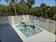 Outdoor deck with a lattice surround, chairs, small table and tropical-themed area rug creates a relaxing retreat at 26456 View Dr, Punta Gorda, FL 33983