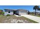 Charming home with a two-car garage and gray exterior paint and a walkway to the front door at 26456 View Dr, Punta Gorda, FL 33983