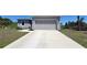 Charming home with a two-car garage, gray paint, and a large concrete driveway at 26456 View Dr, Punta Gorda, FL 33983