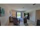 Bright living room with comfortable seating, a large TV, and a sliding glass door leading to an outdoor space at 26456 View Dr, Punta Gorda, FL 33983