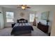 Spacious main bedroom with neutral paint, fan, carpet, two windows, and an accent wall hanging at 26456 View Dr, Punta Gorda, FL 33983