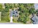 Aerial view of a single-story home in a wooded lot with solar panels, a long driveway, and proximity to neighboring homes at 2666 Barry Rd, North Port, FL 34286