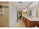 Bathroom with double sinks, granite countertop, stylish mirrors, and a separate shower at 2666 Barry Rd, North Port, FL 34286
