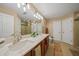 Well-lit bathroom with double sinks, granite countertops, and updated fixtures and a separate toilet at 2666 Barry Rd, North Port, FL 34286