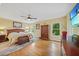 Spacious main bedroom with hardwood floors, natural light, and a ceiling fan at 2666 Barry Rd, North Port, FL 34286