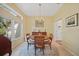 Bright dining room features a round table with a chandelier, large window, and access to multiple rooms at 2666 Barry Rd, North Port, FL 34286