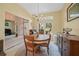 Charming dining room with a round table, chandelier, and ample natural light from a nearby window at 2666 Barry Rd, North Port, FL 34286