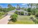 Inviting single-story home featuring a well-manicured lawn, lush landscaping, and a light neutral-toned exterior at 2666 Barry Rd, North Port, FL 34286