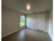 Empty bedroom features wood-look tile flooring, a window with a view, and a five panel door at 337 Rosario St, Punta Gorda, FL 33983