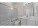 Bright bathroom with a shower-tub combo with sliding doors, a white vanity and a large mirror at 3513 Dileuca St, Punta Gorda, FL 33950