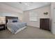 Relaxing bedroom with a tray ceiling and dresser by a window at 3513 Dileuca St, Punta Gorda, FL 33950