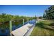 Dock on the water with a canal view surrounded by lush greenery on a beautiful sunny day at 3513 Dileuca St, Punta Gorda, FL 33950