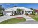 Inviting single-story home with a well-manicured lawn, elegant landscaping, and a pristine white tile roof at 3513 Dileuca St, Punta Gorda, FL 33950