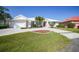 Inviting single-story home with a well-manicured lawn, elegant landscaping, and a pristine white tile roof at 3513 Dileuca St, Punta Gorda, FL 33950