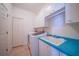 Laundry room with washer, dryer, utility sink with blue counter top, and cabinets at 3513 Dileuca St, Punta Gorda, FL 33950