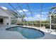 Screened-in pool area with tropical landscaping and a waterway view at 3513 Dileuca St, Punta Gorda, FL 33950