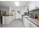 Bright kitchen with granite counters, white cabinets, and stainless steel appliances at 3520 Kenneth Rd, Port Charlotte, FL 33953