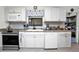 Well-lit kitchen features stainless steel appliances and white cabinets with modern countertops at 3520 Kenneth Rd, Port Charlotte, FL 33953