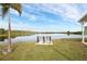 Breathtaking lake view featuring a bench, palm tree, and serene water reflecting the sky at 3520 Kenneth Rd, Port Charlotte, FL 33953