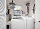 Efficient laundry room with full size washer and dryer, storage cabinet, and hanging rack at 3520 Kenneth Rd, Port Charlotte, FL 33953