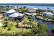 Aerial view of home and waterfront with private boat dock, lush landscape, and screened in lanai at 3712 Balboa Ct, Punta Gorda, FL 33983