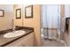 Well-lit bathroom features a vanity, mirror, and shower with a neutral-toned shower curtain at 3712 Balboa Ct, Punta Gorda, FL 33983